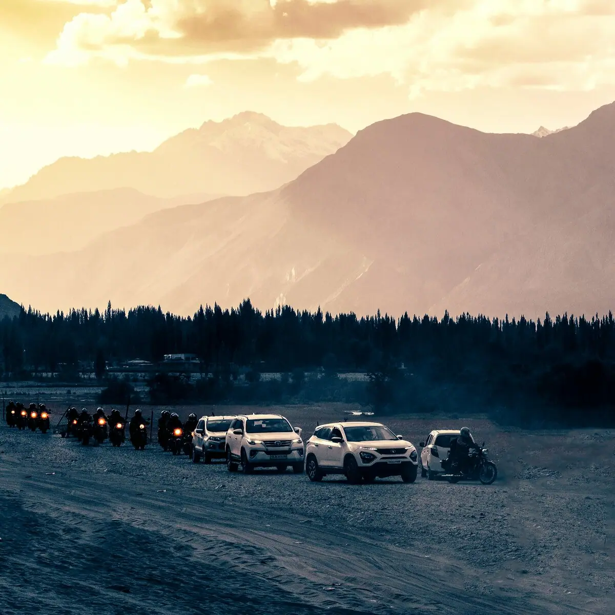 Convoy of cars gathered in the mountains at dusk